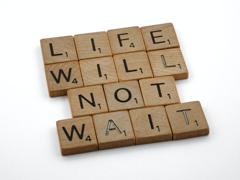 Letter blocks that spell out “life will not wait”