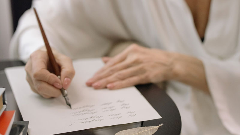 An older woman is writing her will.